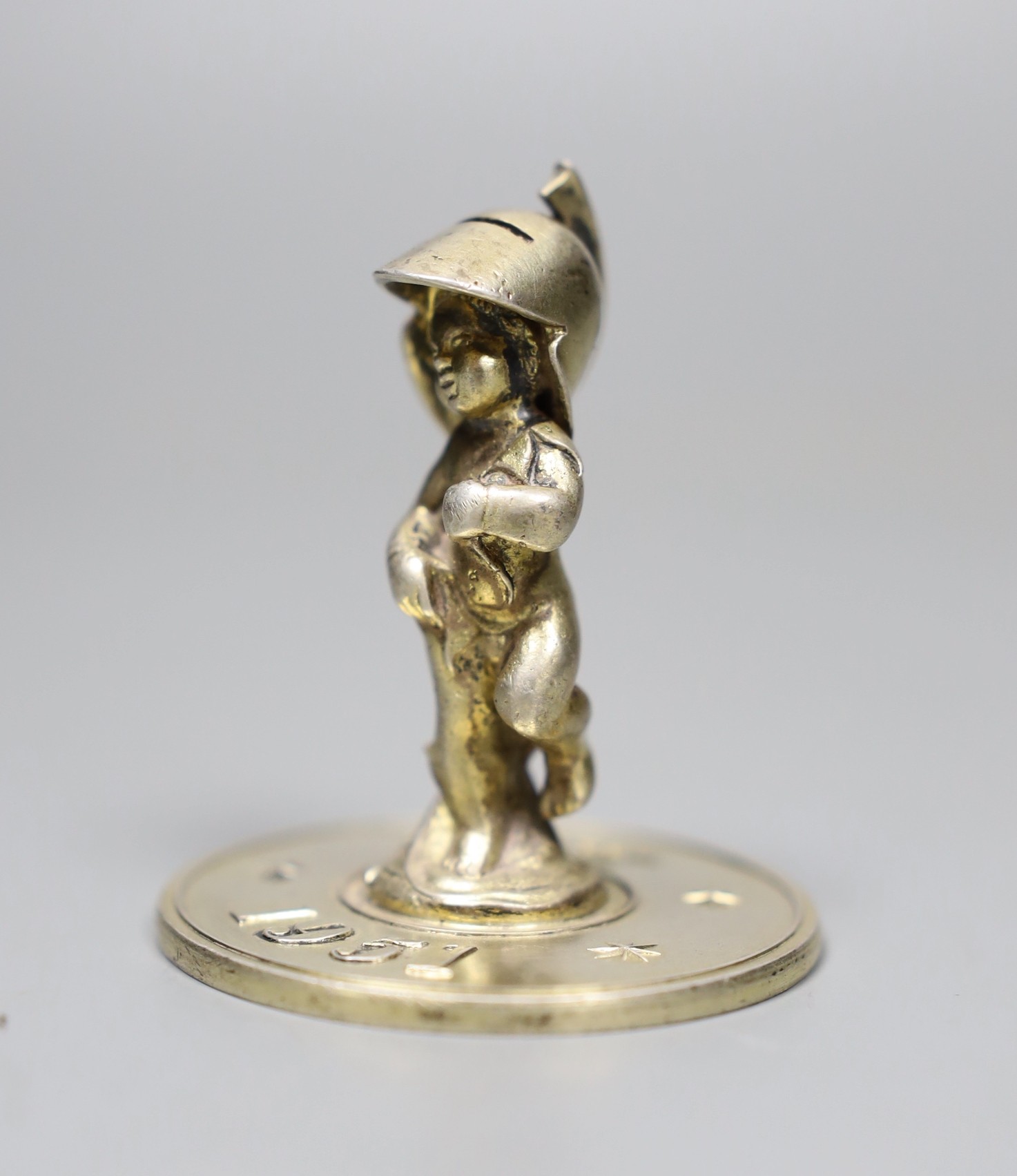 A silver-gilt Festival of Britain figural paperweight, Lesley Gordon Durbin, London 1950, 5cm